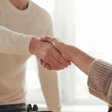 Two person sharing a handshake after a successful business deal with the title that says Success Stories with Mayk